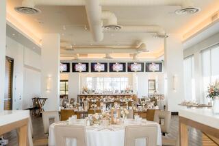 A stylish banquet hall features elegantly set tables, soft lighting, and modern decor, creating a warm and inviting atmosphere.