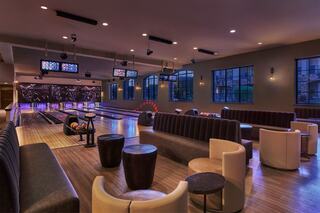 A stylish bowling alley features plush seating, sleek lanes, and vibrant lighting, creating a modern and inviting atmosphere for fun and relaxation.