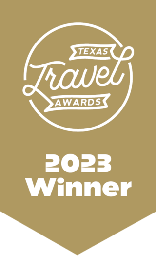A gold banner featuring the Texas Travel Awards logo, highlighting "2023 Winner" in bold white letters.