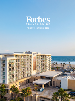 A modern hotel with ocean views, featuring palm trees and a welcoming entrance, highlighted as a recommended destination for 2026.